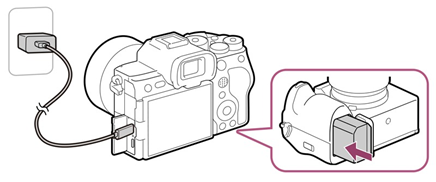 Ilustração do carregamento de uma bateria (ou fornecimento de alimentação à câmara) pela inserção da bateria na câmara e depois utilizar um cabo USB Type-C (USB-C – USB-C) para ligar a câmara ao terminal USB Type-C de um dispositivo compatível com USB PD