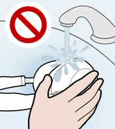 Illustration of an improper cleaning method: rinsing the headphones under running water.