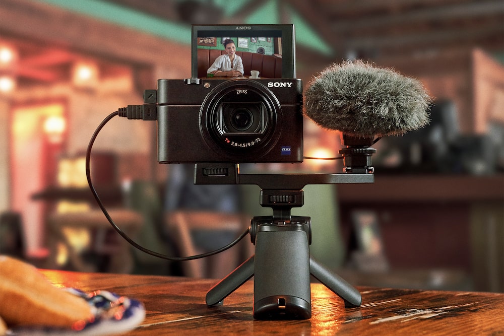 Sony RX100 VII camera mounted on a shooting grip and shown with an optional external microphone