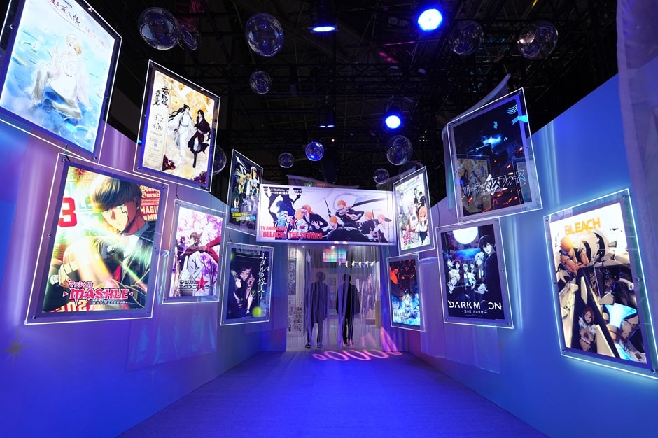 白い空間に複数のアニメ作品のポスターが展示されている様子