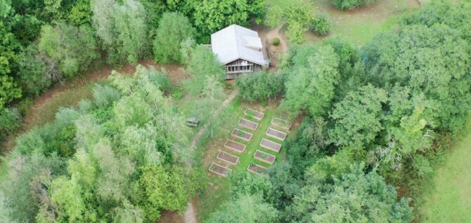 ソニーUK Technology Centreの環境センターの空撮写真。建物の小さな白い屋根と小規模農園が広々とした緑の中で木々に囲まれている。